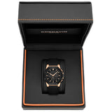 A Cornavin wristwatch with a black dial and strap, featuring rose gold accents on the case and indices, presented inside its open black textured gift box with orange stitching.
