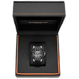 A black Cornavin wristwatch displayed inside an open black presentation box with orange stitching and a black interior. The watch has a dark dial, silver-toned case details, and a black strap.